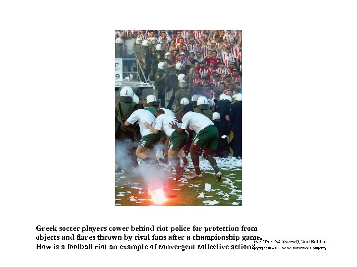 Greek soccer players cower behind riot police for protection from objects and flares thrown