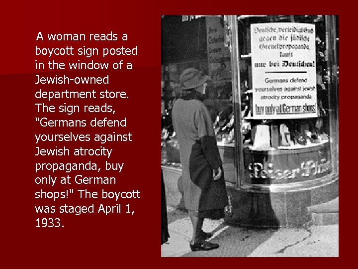  A woman reads a boycott sign posted in the window of a Jewish-owned