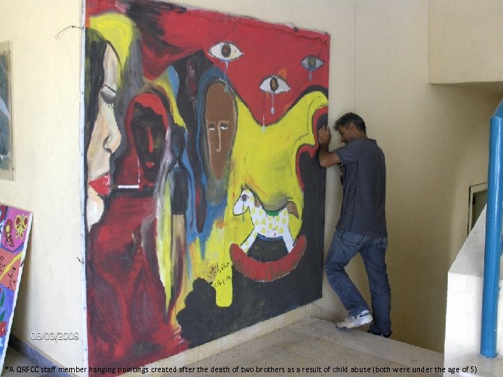 *A QRFCC staff member hanging paintings created after the death of two brothers as