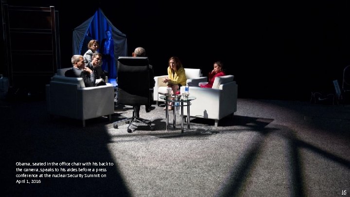 Obama, seated in the office chair with his back to the camera, speaks to