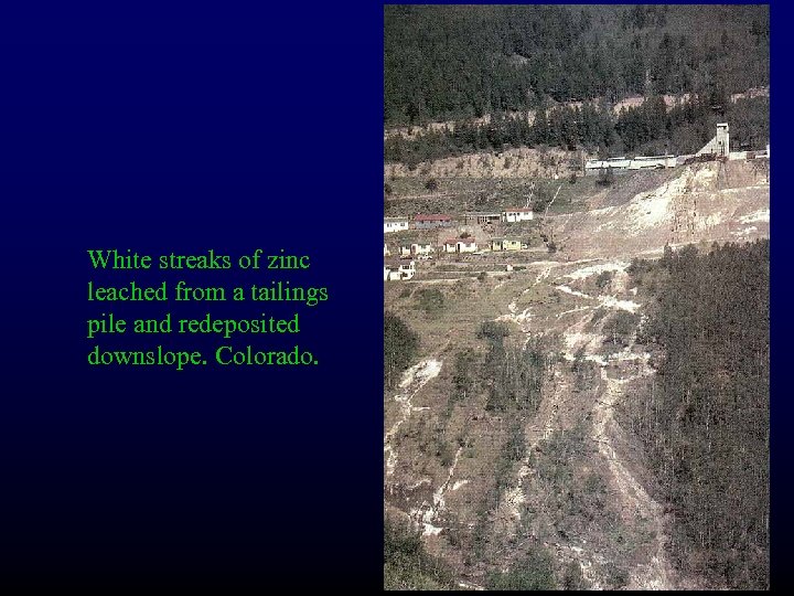 White streaks of zinc leached from a tailings pile and redeposited downslope. Colorado. 