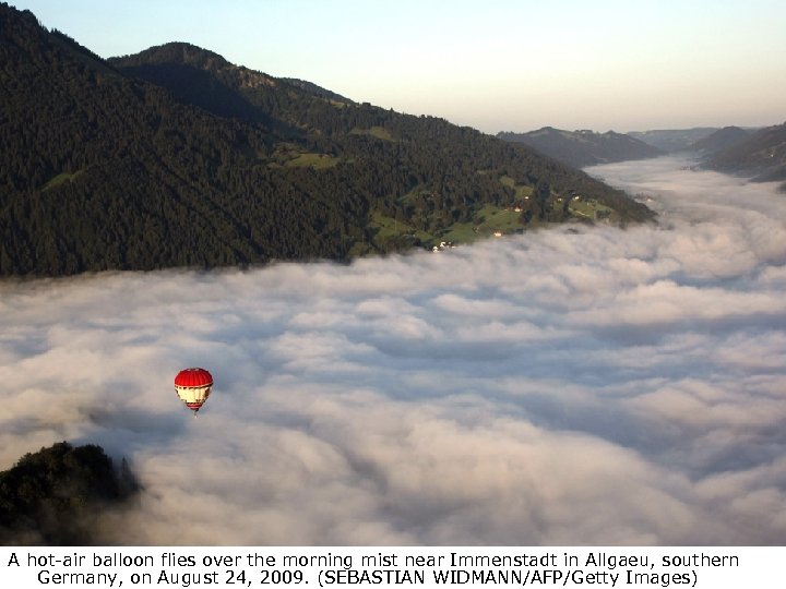 A hot-air balloon flies over the morning mist near Immenstadt in Allgaeu, southern Germany,