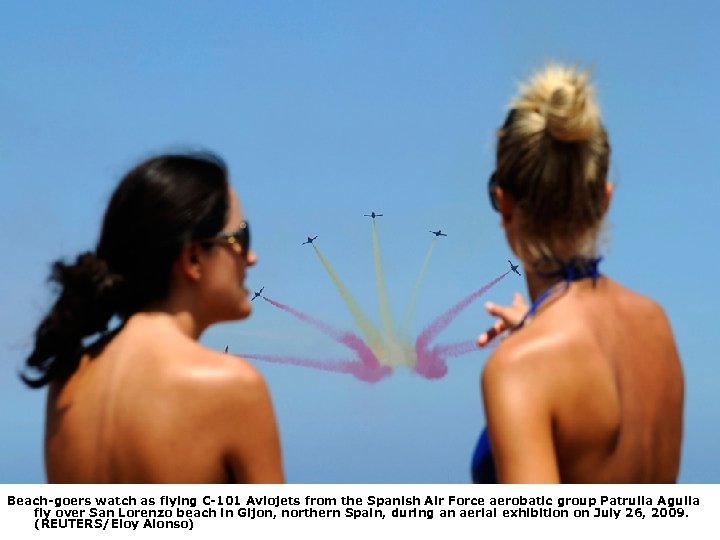 Beach-goers watch as flying C-101 Aviojets from the Spanish Air Force aerobatic group Patrulla