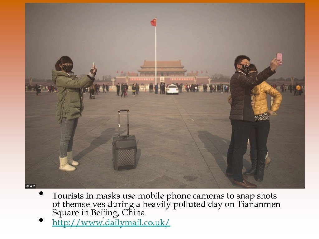  • • Tourists in masks use mobile phone cameras to snap shots of