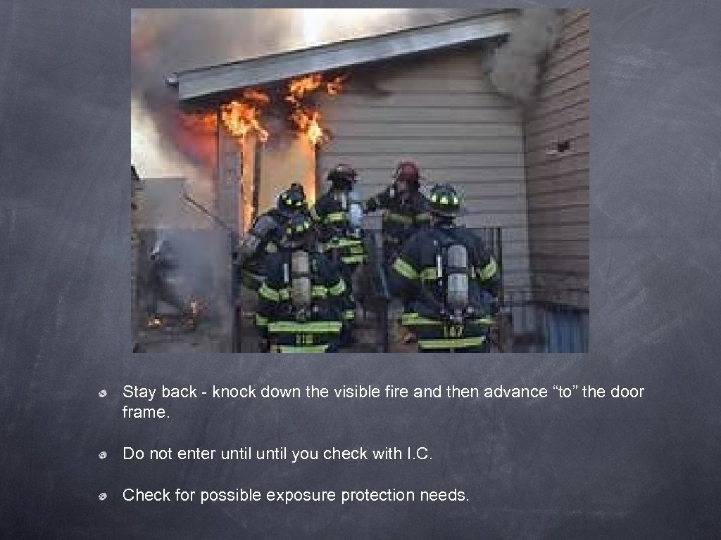 Stay back - knock down the visible fire and then advance “to” the door