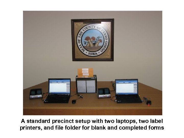 A standard precinct setup with two laptops, two label printers, and file folder for