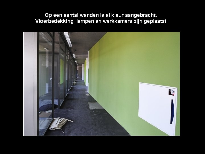 Op een aantal wanden is al kleur aangebracht. Vloerbedekking, lampen en werkkamers zijn geplaatst