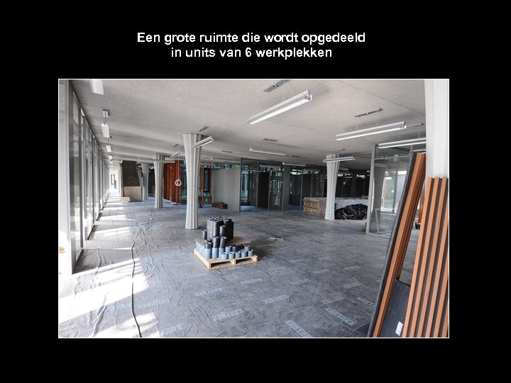 Een grote ruimte die wordt opgedeeld in units van 6 werkplekken 