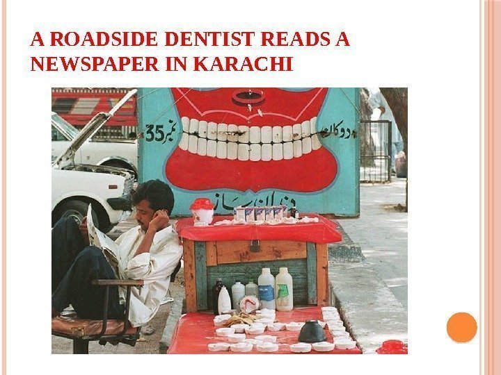 A ROADSIDE DENTIST READS A NEWSPAPER IN KARACHI 